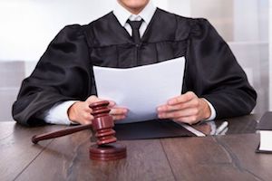 A judge at the bench reading a document.
